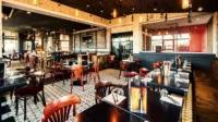 Modern restaurant interior with wooden tables and pendant lights