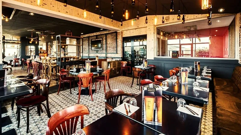 Modern restaurant interior with wooden tables and pendant lights
