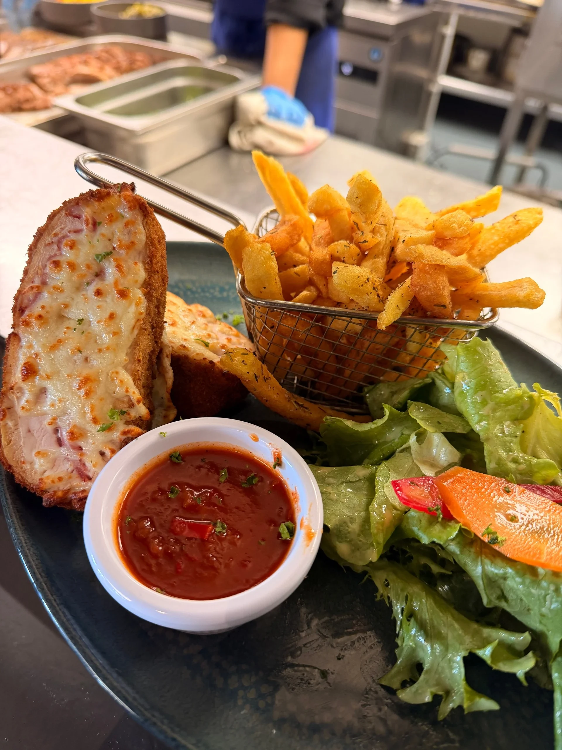 Croque monsieur with fries, salad, and tomato sauce