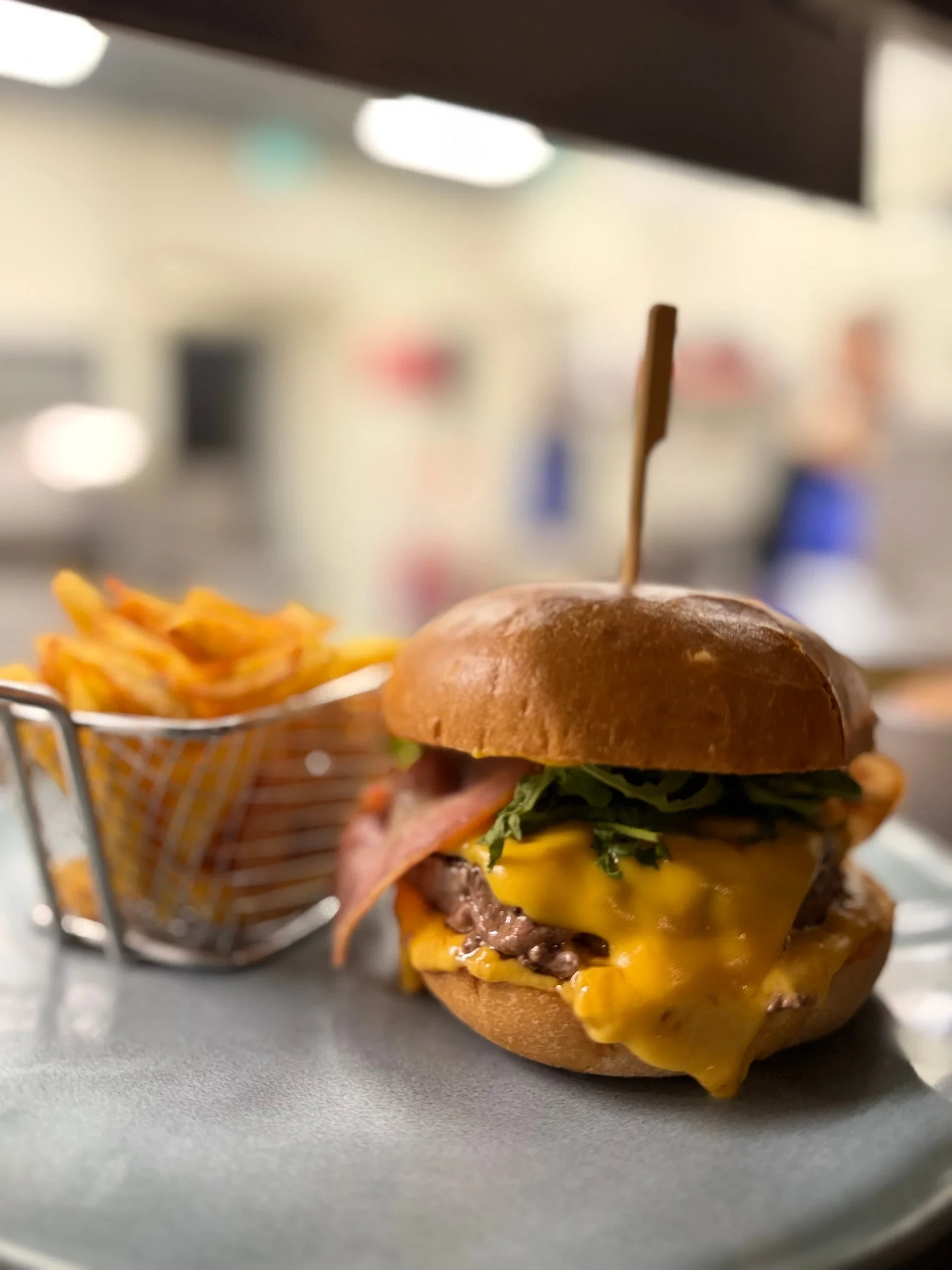 Cheeseburger with bacon and fries on table